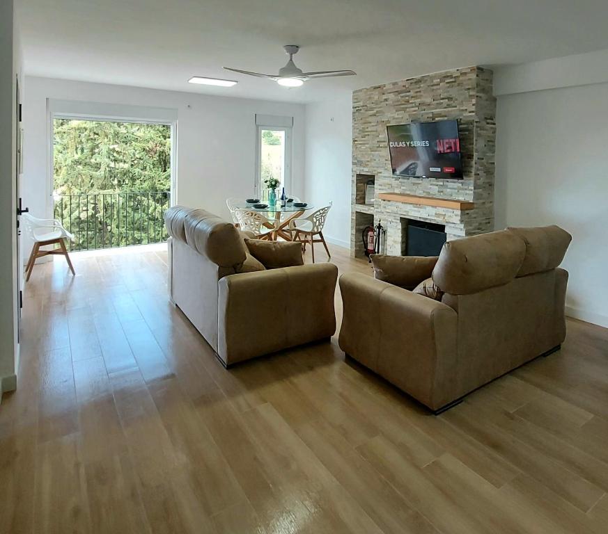 Una sala de estar con dos sofás y una chimenea. en Casa Rural Benamahoma, en Benamahoma