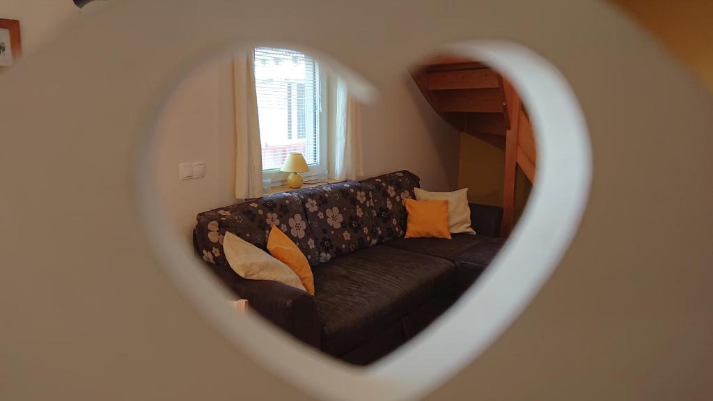a couch in a living room through a mirror at Apartments Na Vasi in Bohinj