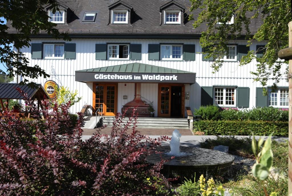 a building with a fountain in front of it at Gästehaus Warsteiner Welt in Warstein