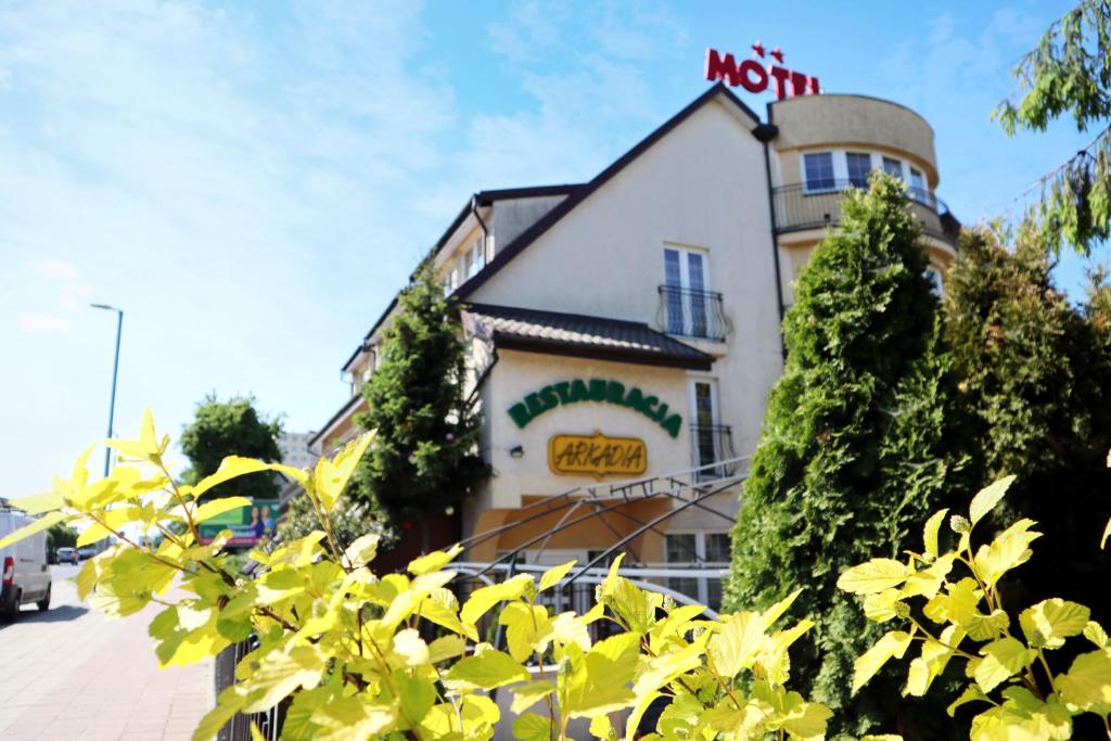 een gebouw met een uithangbord aan de zijkant bij Motel Arkadia in Koszalin