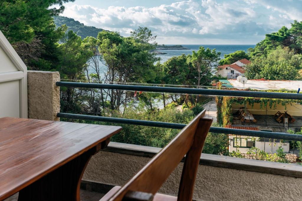 a balcony with a wooden bench and a view of the ocean at Apartments Pitarević in Saplunara