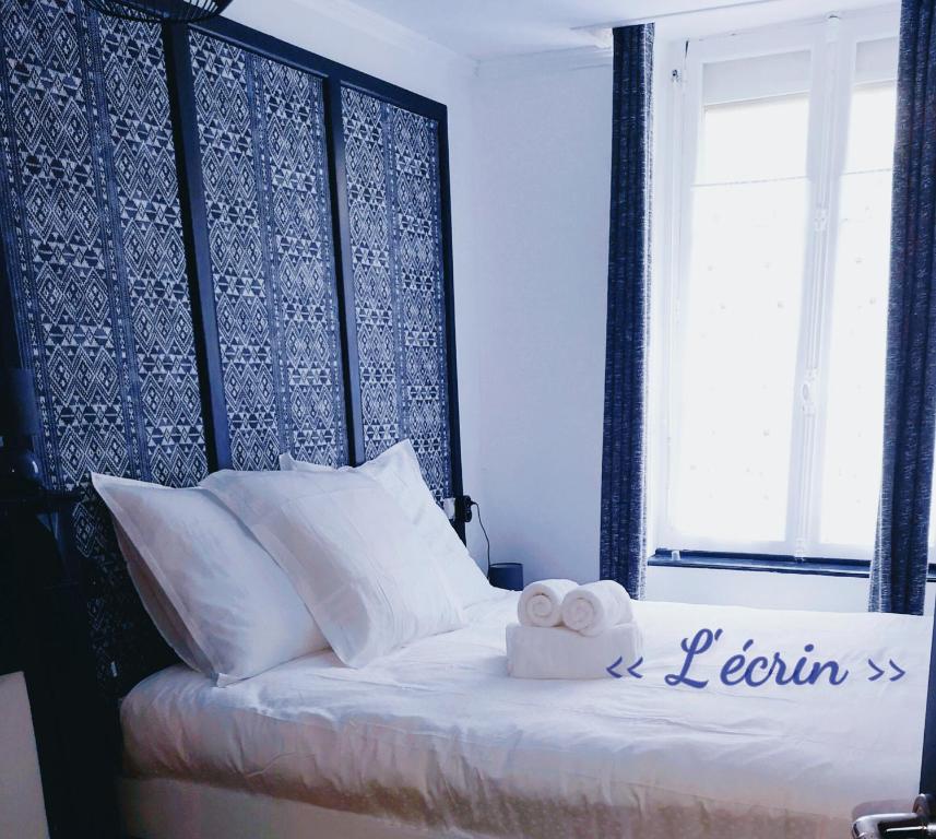 um quarto com uma cama com duas toalhas em Au cœur des remparts, L'ÉCRIN Appartement 2 chambres pour 2-6 pers em Saint Malo