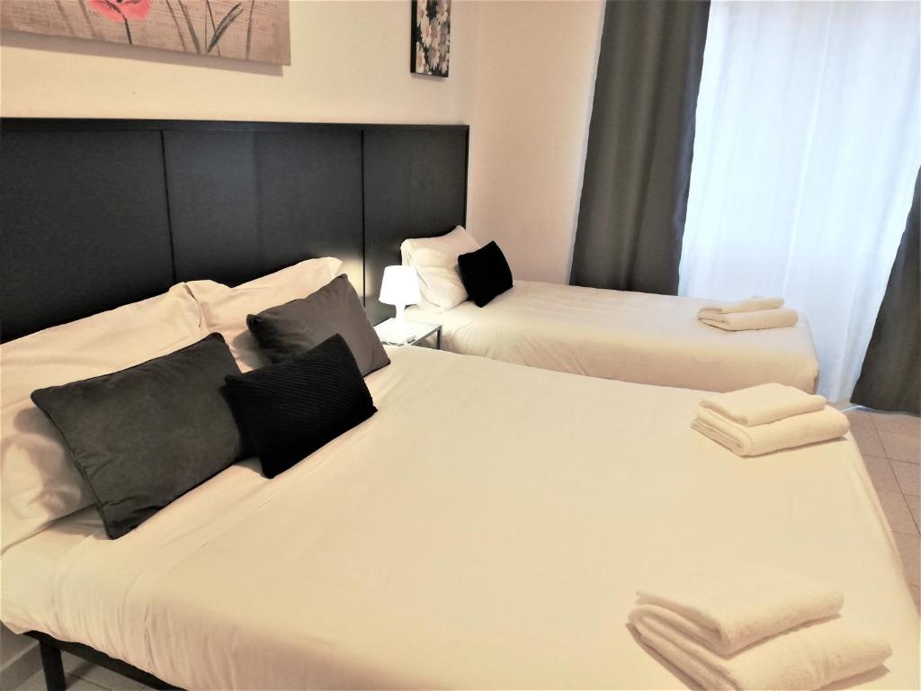a hotel room with two beds and a couch at Pero Apartment - Fiera Milano in Pero