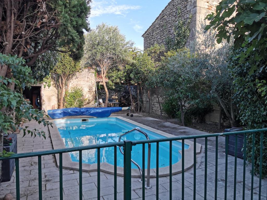 basen w ogrodzie z ogrodzeniem w obiekcie La Maison d'à Côté w mieście Mus