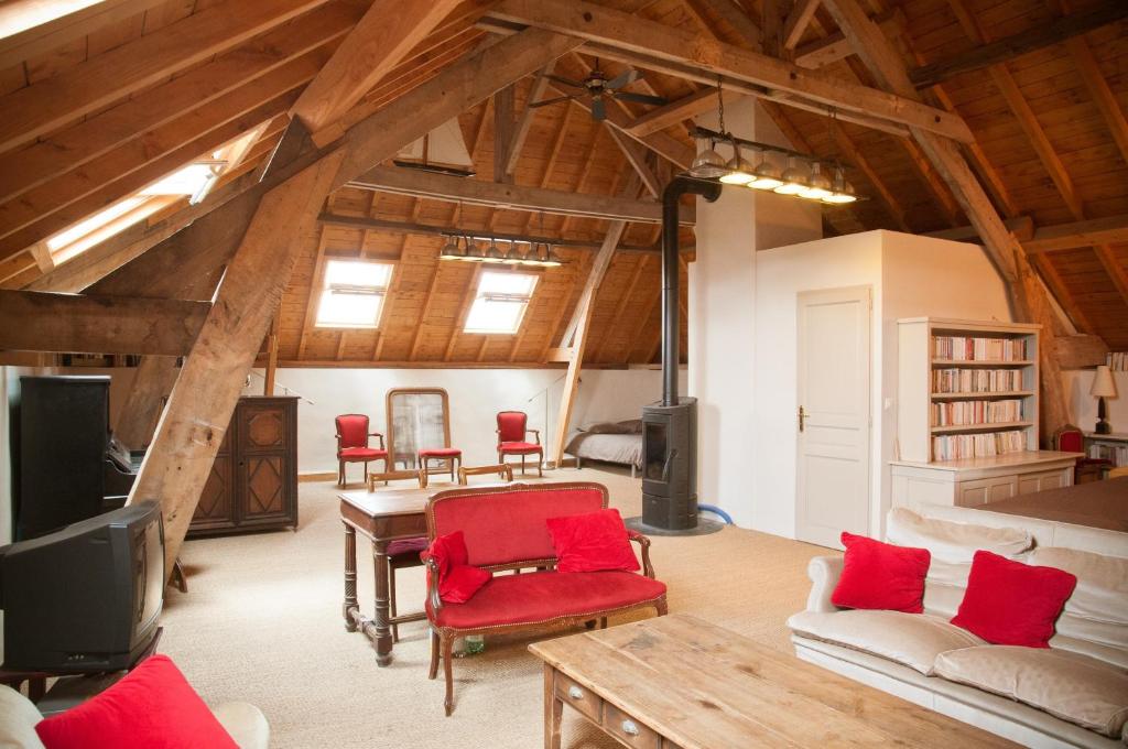 ein Wohnzimmer mit roten Stühlen und einem TV in der Unterkunft Chambre d'Hôtes des Grands Moulins de Baugé in Baugé