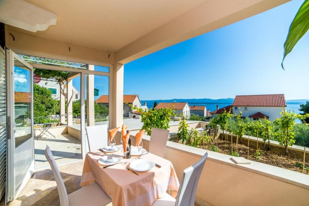 una mesa y sillas en un balcón con vistas al océano en Apartment in Bol with sea view, terrace, air conditioning, WiFi 3739-2 en Bol