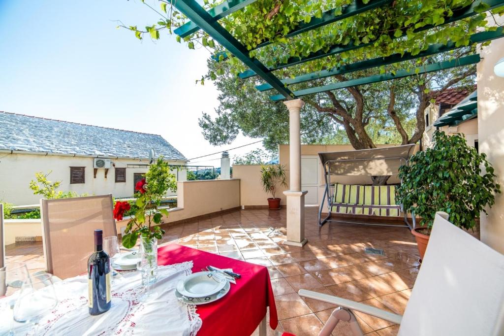 un patio con mesa y mantel rojo en Apartment in Bol with sea view, terrace, air conditioning, WiFi 3739-3 en Bol
