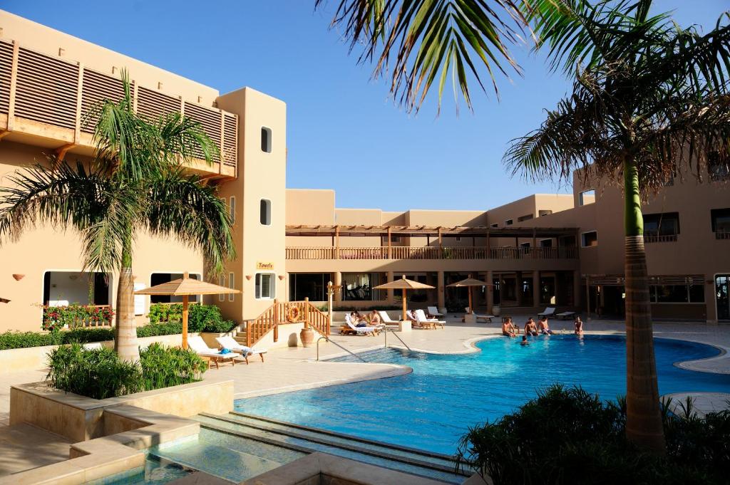 um resort com piscina e palmeiras em The Breakers Diving and Surfing Lodge Soma Bay em Hurghada
