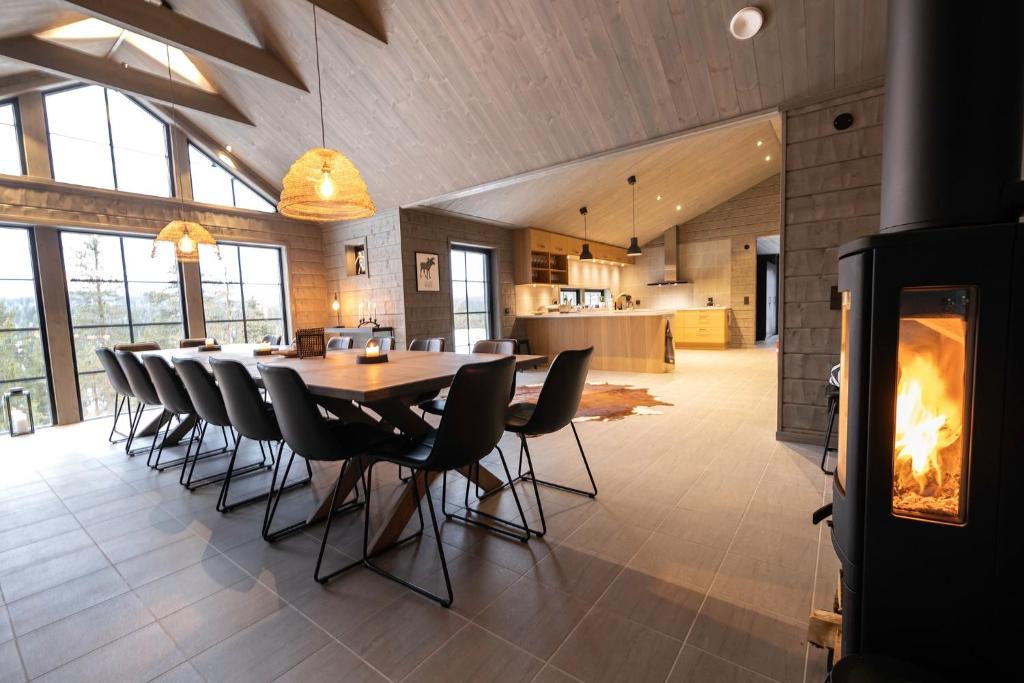 a dining room with a table and chairs and a fireplace at Sälen Mountain Lodge in Sälen