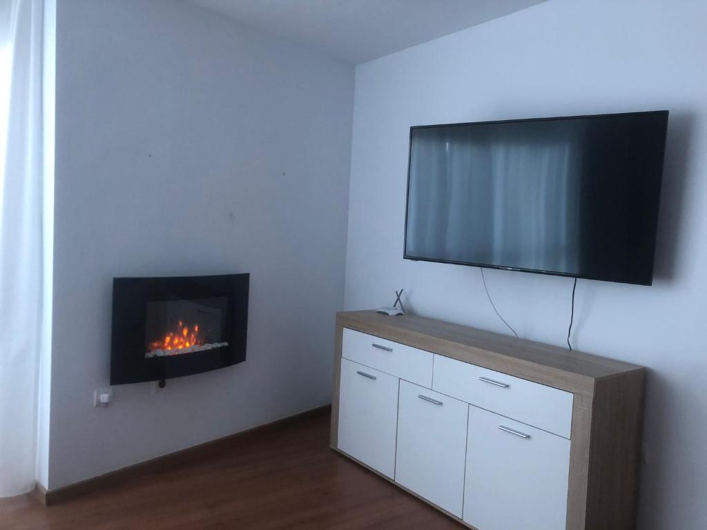 a living room with a fireplace and a flat screen tv at Granada-Cogollos Vega Village in Cogollos De La Vega