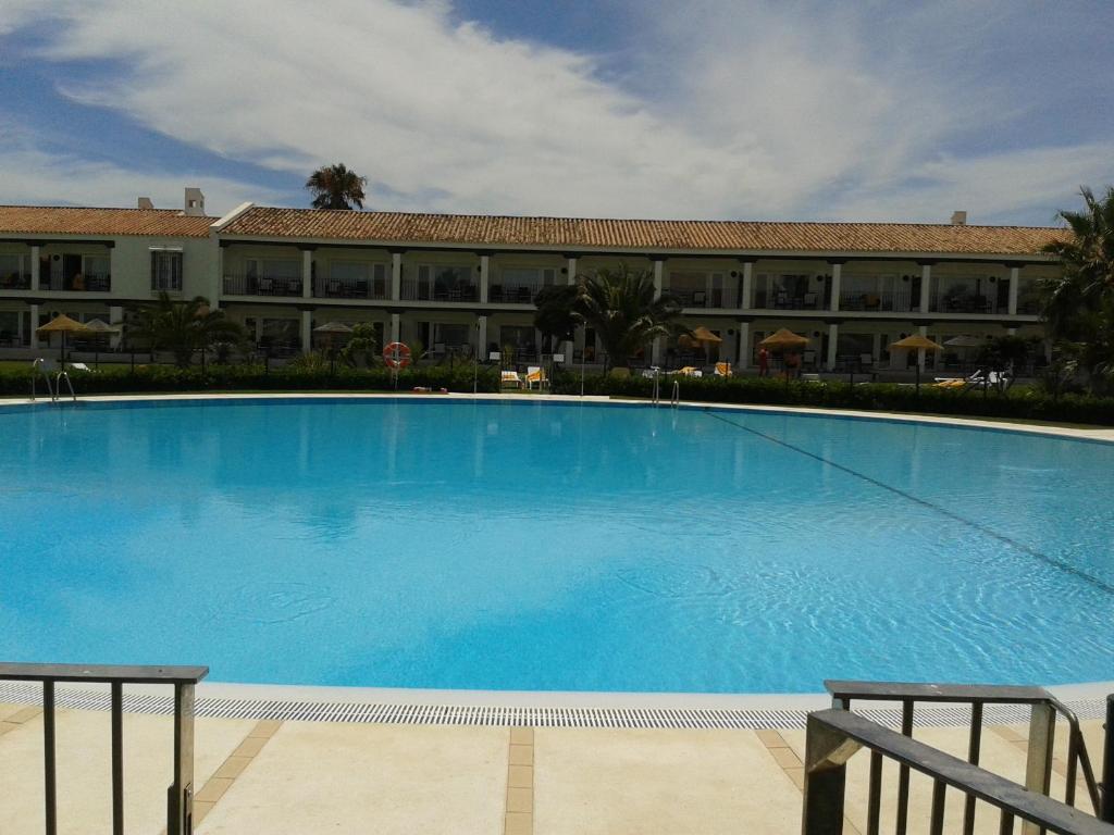 a large blue swimming pool in front of a building at Parador de Málaga Golf in Málaga