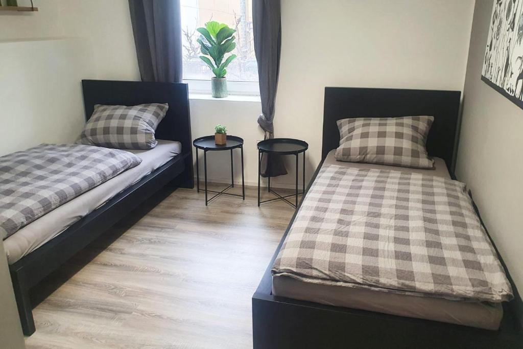 a bedroom with two beds and two tables at Work & Stay apartment Vohburg near Ingolstadt in Vohburg an der Donau