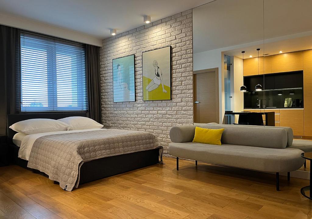 sypialnia z łóżkiem i kanapą w obiekcie Apartamenty Modern Gdynia w mieście Gdynia
