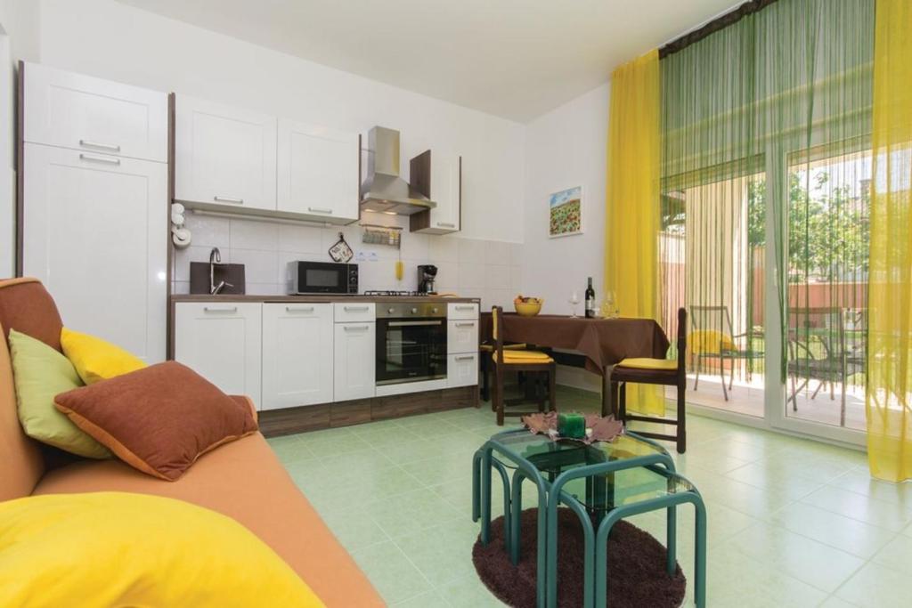 eine Küche und ein Wohnzimmer mit einem Sofa und einem Tisch in der Unterkunft Two Bedroom Apartment Valdebecco for 5 persons in Pula