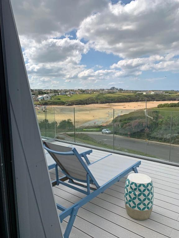 纽基Porth Beach Hotel的海滩景门廊上的蓝色摇椅