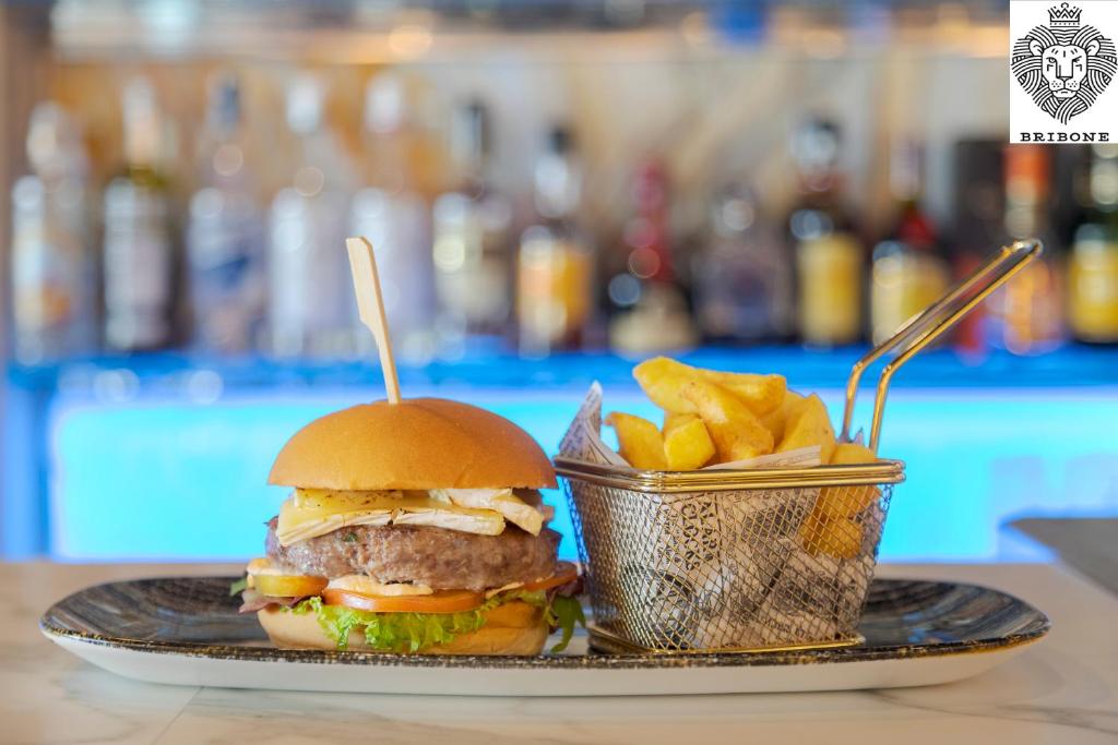 a sandwich and a basket of fries on a plate at Melia Alicante in Alicante