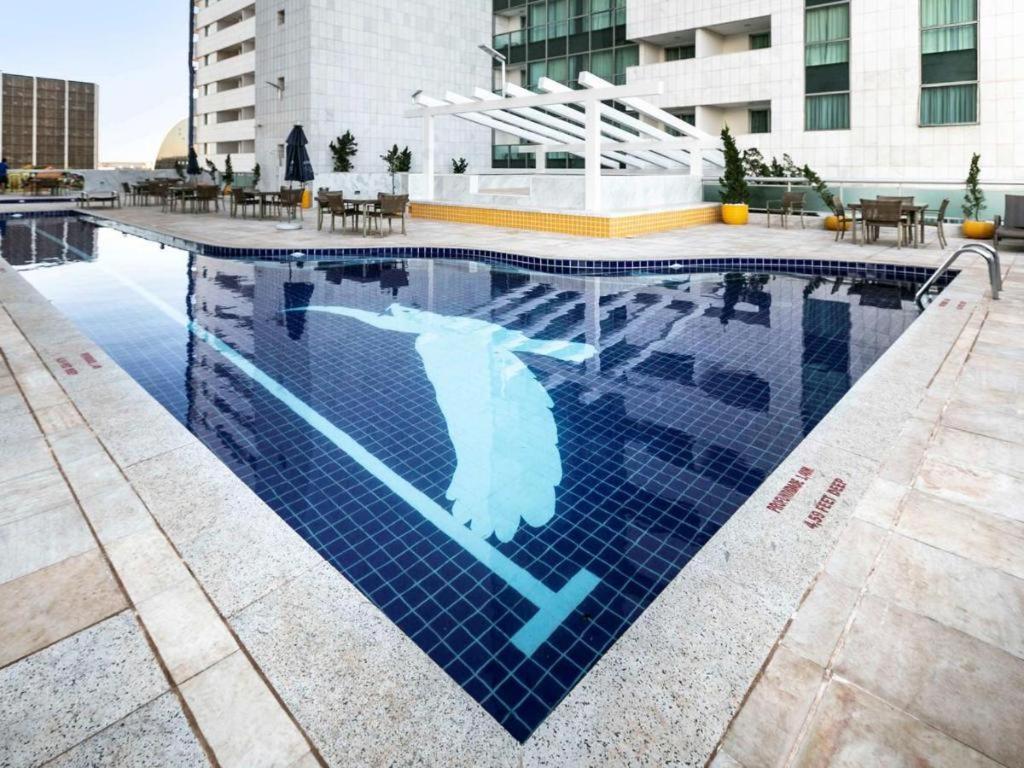 a swimming pool with a sign in the water at Flat Brasília Líder - Eixo Monumental in Brasilia
