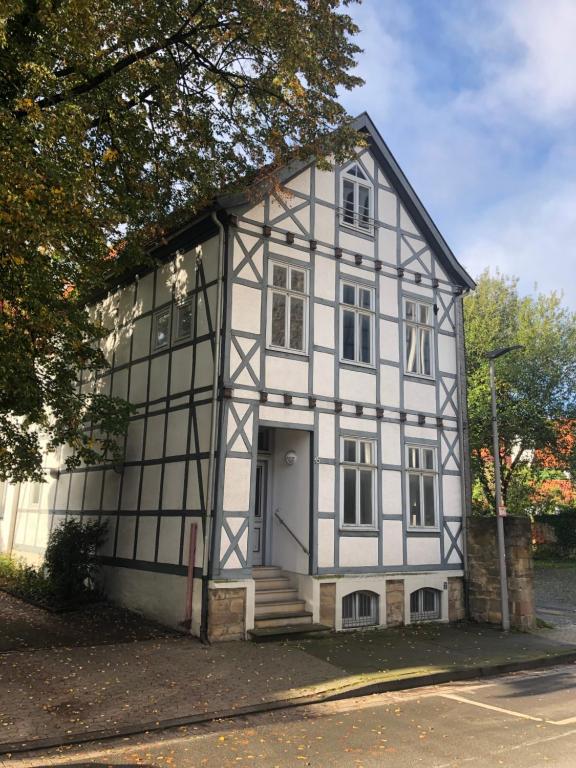 een wit en zwart huis met een veranda bij Ferienhaus Lütt Hüsken in Lemgo