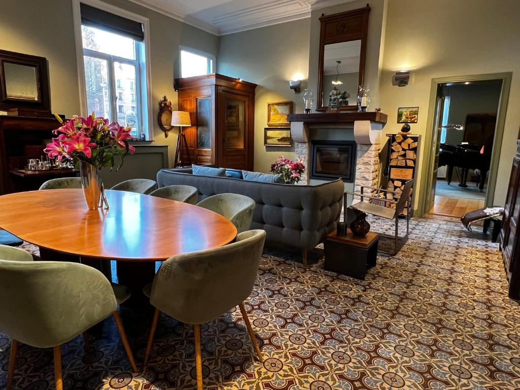 uma sala de estar com uma mesa e cadeiras e um sofá em B&B Den Engel em Kortenberg