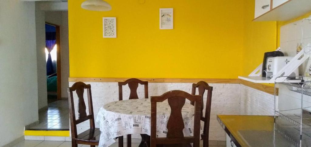 una mesa con 2 sillas en una cocina con una pared amarilla en Casa Nona Rosa en San Carlos de Bariloche