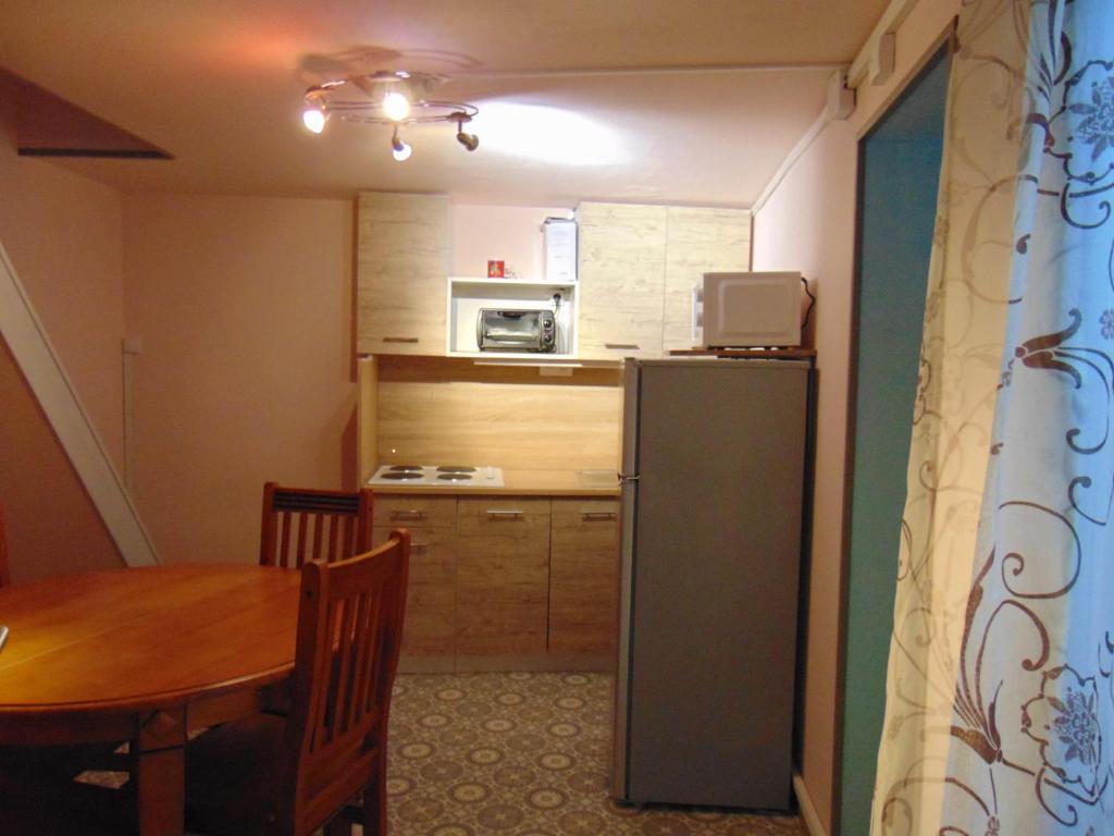 une petite cuisine avec une table et un réfrigérateur dans l'établissement Maison Hélie, à Avignon