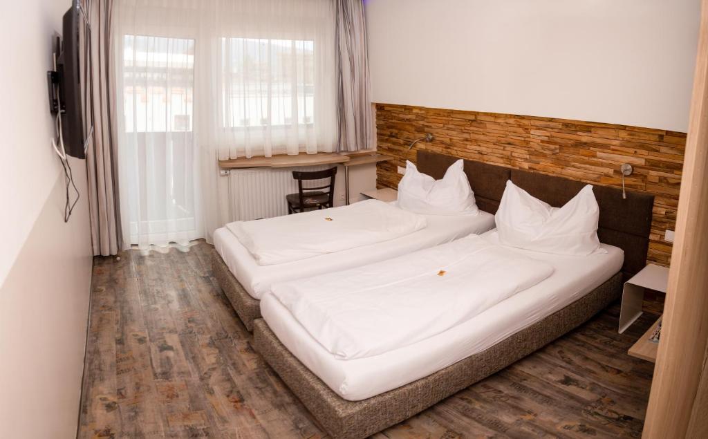 2 Betten in einem Zimmer mit weißer Bettwäsche in der Unterkunft Burg Rooms in Spielberg