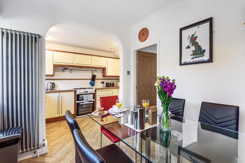 a kitchen and dining room with a glass table and chairs at Bishy Road Hideaway near York Racecourse in York