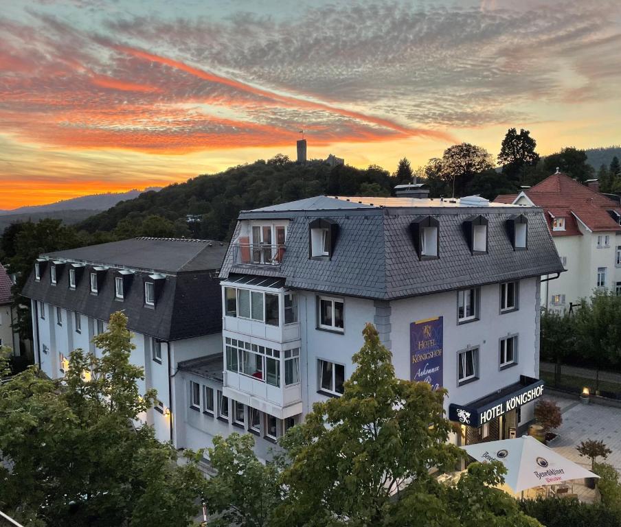 ein großes weißes Gebäude mit Sonnenuntergang im Hintergrund in der Unterkunft Königshof Bed and Breakfast in Königstein im Taunus