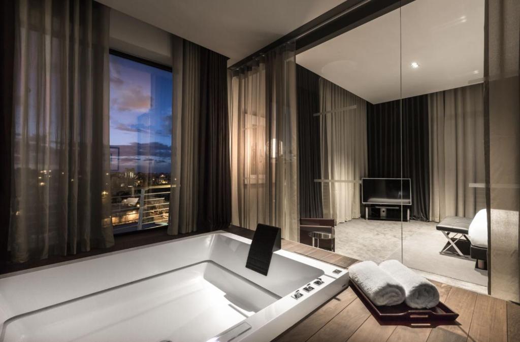 a bath tub in a room with a large window at InterContinental Malta by IHG in St Julian's