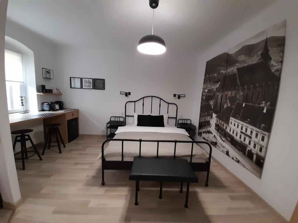 a bedroom with a bed and a desk in it at Apartment BIANCA in Braşov