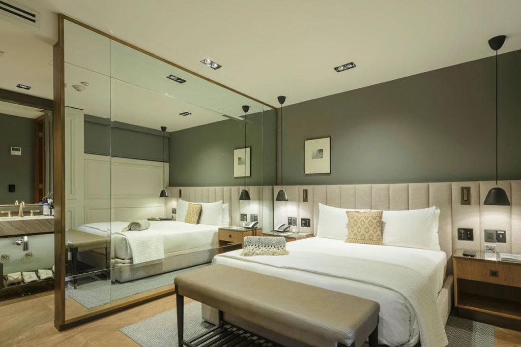 a large bedroom with two beds and a mirror at Brick Hotel Mexico City - Small Luxury Hotels of the World in Mexico City