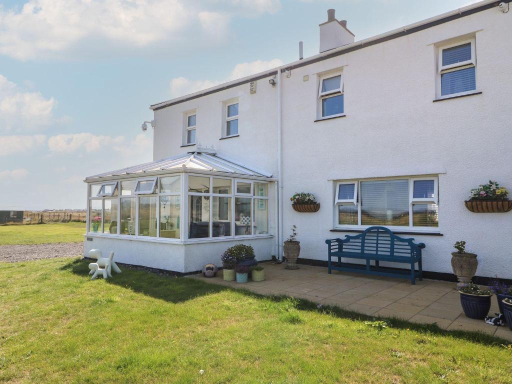 a white house with a conservatory in front of it at Trewan House in Holyhead