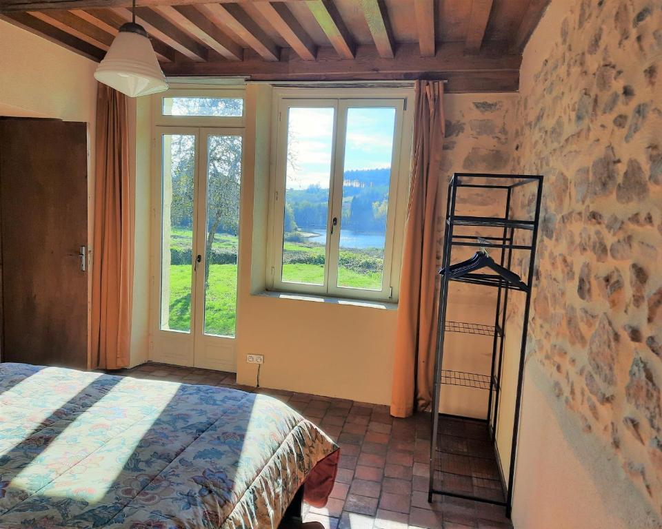 1 dormitorio con 1 cama, escalera y ventanas en Gite de l'étang Rangère, en Villapourçon