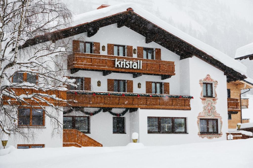 a snow covered building with a balcony on top of it at Hotel Kristall in Lech am Arlberg