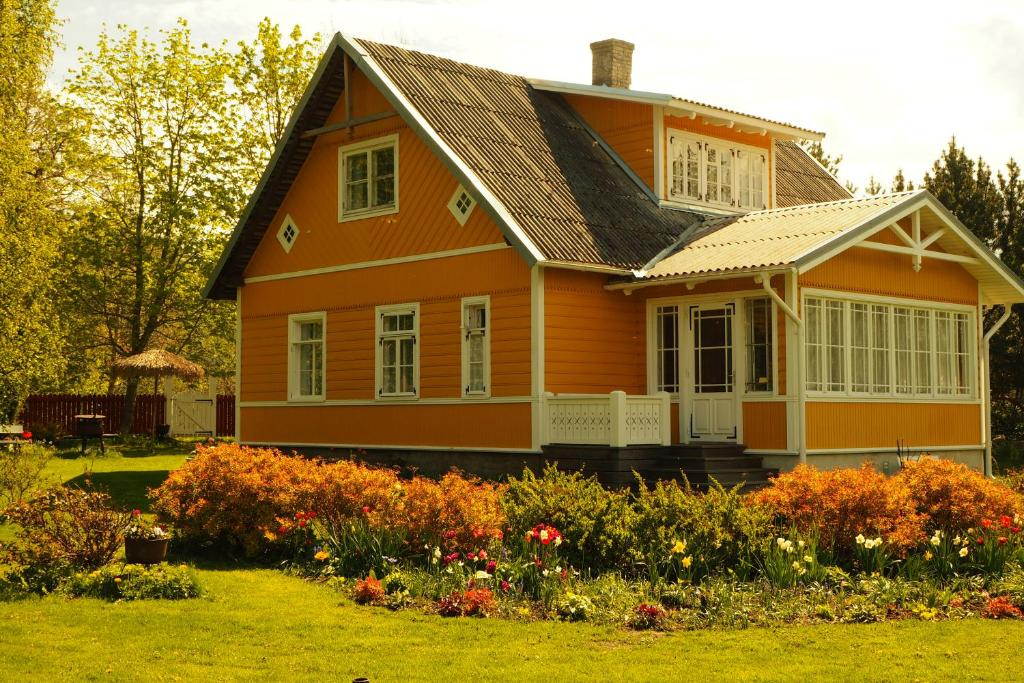 an orange house with a garden in front of it at Leesi Puhkemaja in Leesi