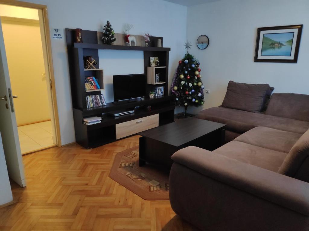 a living room with a couch and a christmas tree at Apartment Knez in Kolašin