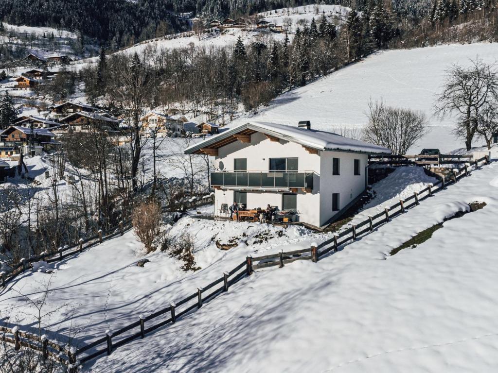 a white house in the snow with a fence at Holiday Home Pfisterer by Interhome in Taxenbach