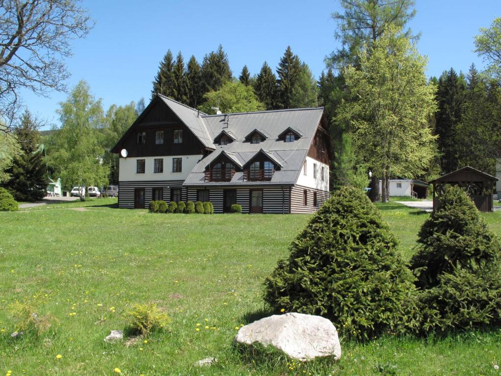 ein großes schwarzweißes Haus mit einem Baum im Hof in der Unterkunft Apartment Harrachovka - HRA102 by Interhome in Harrachov