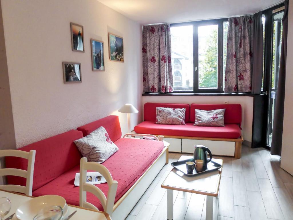 a living room with two red couches and a table at Apartment Jonquilles-7 by Interhome in Chamonix