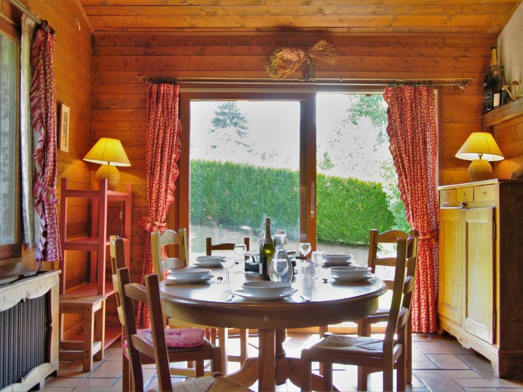 una sala da pranzo con tavolo, sedie e finestra di Chalet L'Piri by Interhome a Chamonix-Mont-Blanc