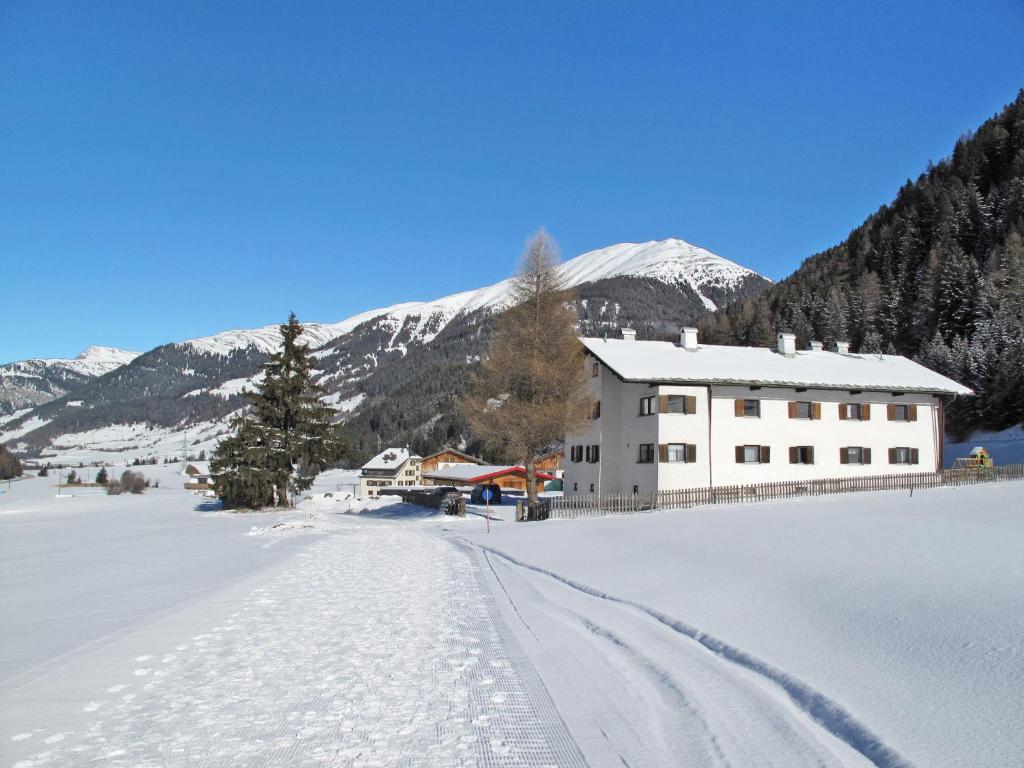 a house in the snow with mountains in the background at Apartment Altes Zollhaus-4 by Interhome in Nauders