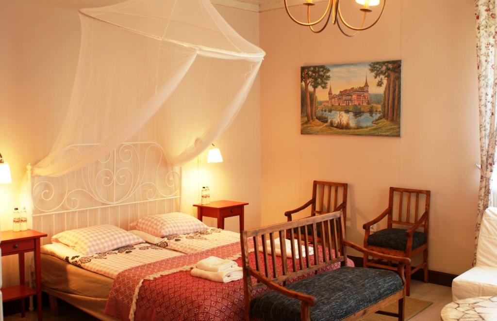 a bedroom with two beds and two chairs at Pokoje Przy Stoczku in Białowieża