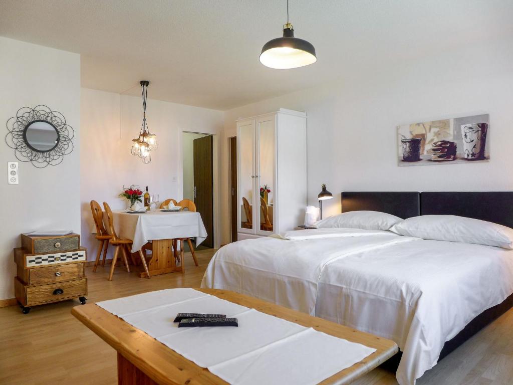 ein Schlafzimmer mit einem Bett und einem Tisch sowie ein Esszimmer in der Unterkunft Apartment Chesa Ova Cotschna 303 by Interhome in St. Moritz