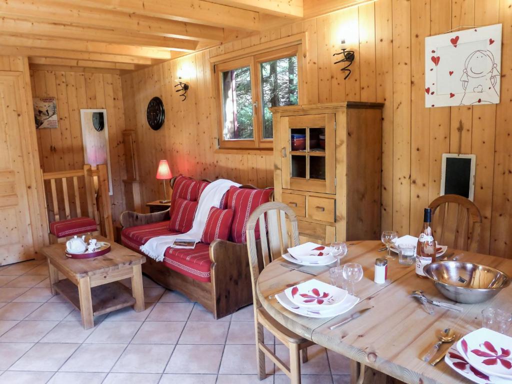 een woonkamer met een tafel en een bank bij Chalet Evasion by Interhome in Les Bossons