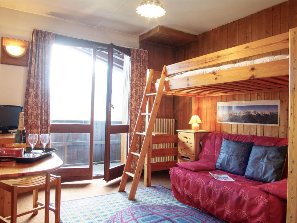a living room with a bunk bed and a red couch at Apartment Les Periades by Interhome in Chamonix