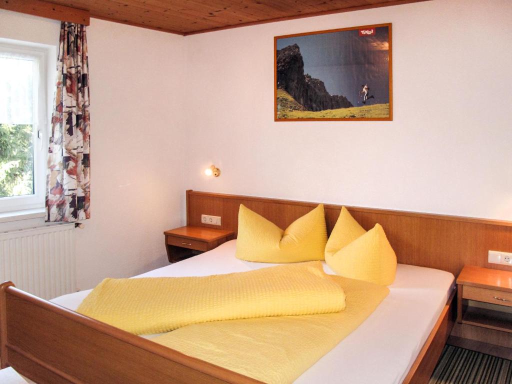 sypialnia z łóżkiem z żółtymi poduszkami w obiekcie Apartment Helga-2 by Interhome w mieście Tobadill