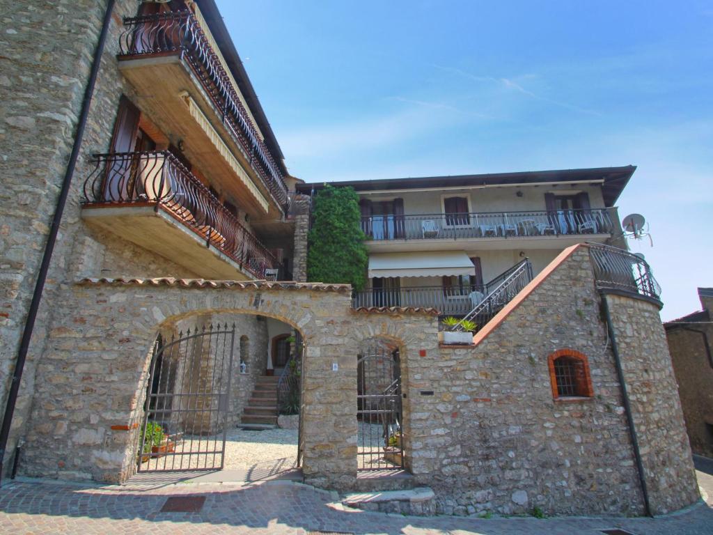 een stenen gebouw met een poort en een balkon bij Apartment Adalgisa-1 by Interhome in Tignale