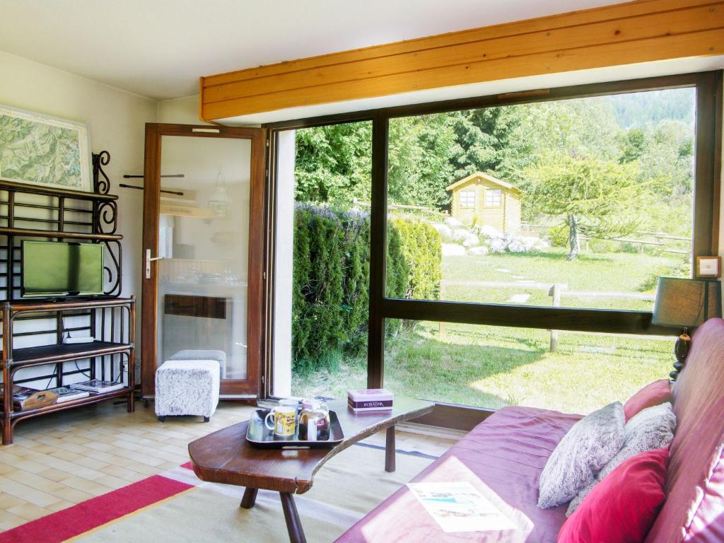 a living room with a couch and a large window at Holiday Home Les Pelarnys by Interhome in Chamonix