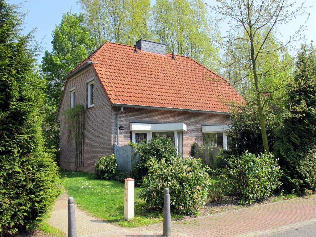 una pequeña casa de ladrillo con techo naranja en Holiday Home Tossens-6 by Interhome en Tossens