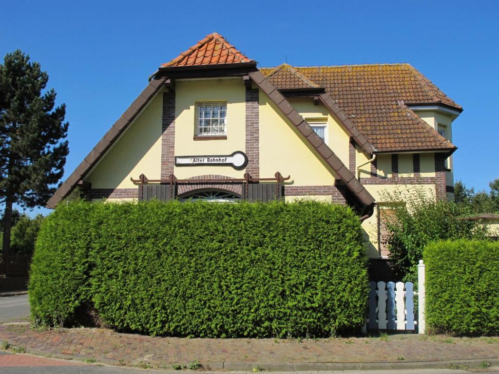 una casa con un seto delante de ella en Apartment Alter Bahnhof by Interhome en Neugarmssiel